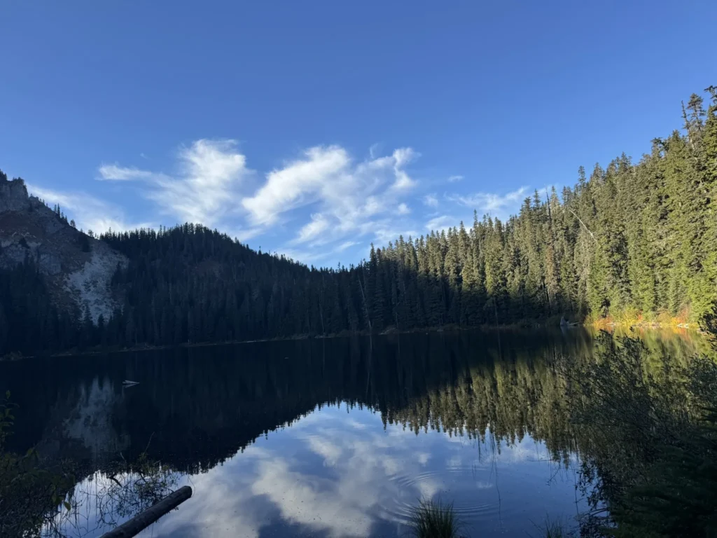 Picture of a lake with the mountains in the background and the blue sky above.